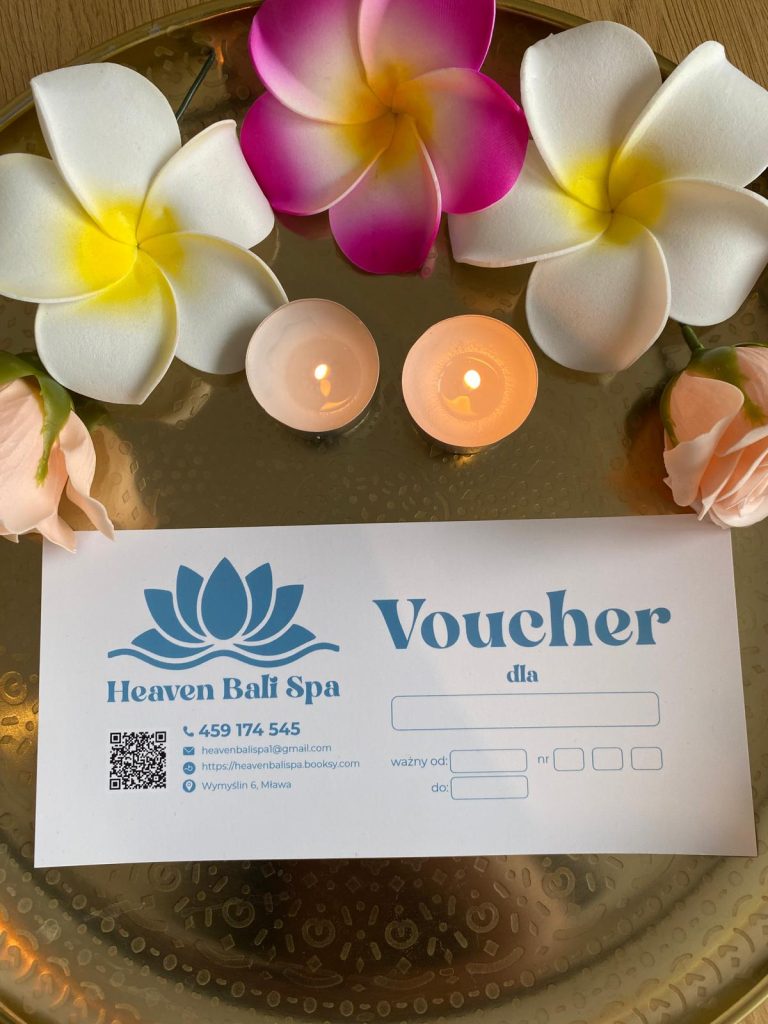 Voucher Heaven Bali Spa na złotym tacy z kwiatami frangipani i zapalonymi świecami